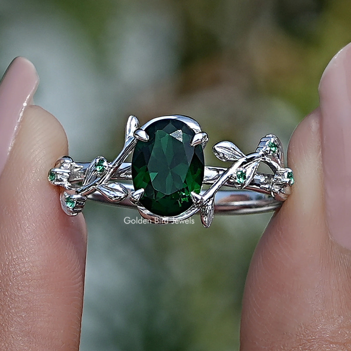 Silver oval green gemstone engagement ring with prong setting and leafy split shank