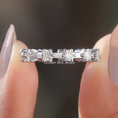 Round moissanite eternity band with silver setting and multiple clear round stones, close-up