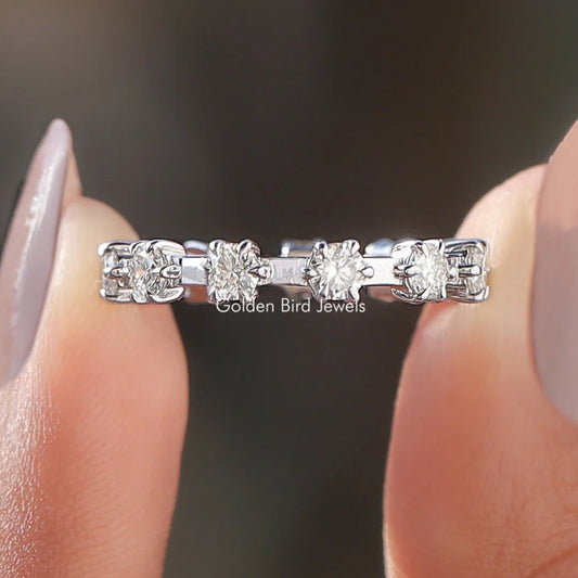 Round moissanite eternity band with silver setting and multiple clear round stones, close-up