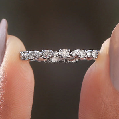 Silver eternity wedding band with round moissanite stones, shared prong setting