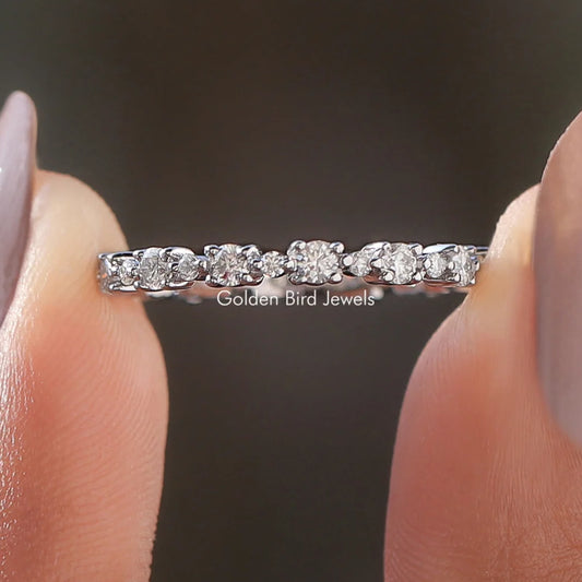 Silver eternity wedding band with round moissanite stones, shared prong setting