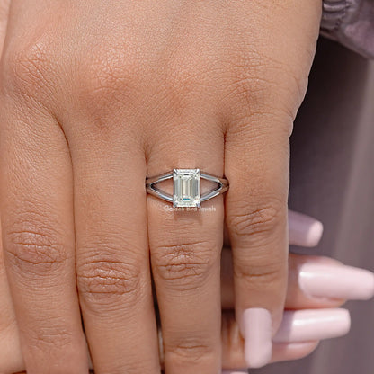 Sterling silver split-shank ring with emerald-cut stone on hand