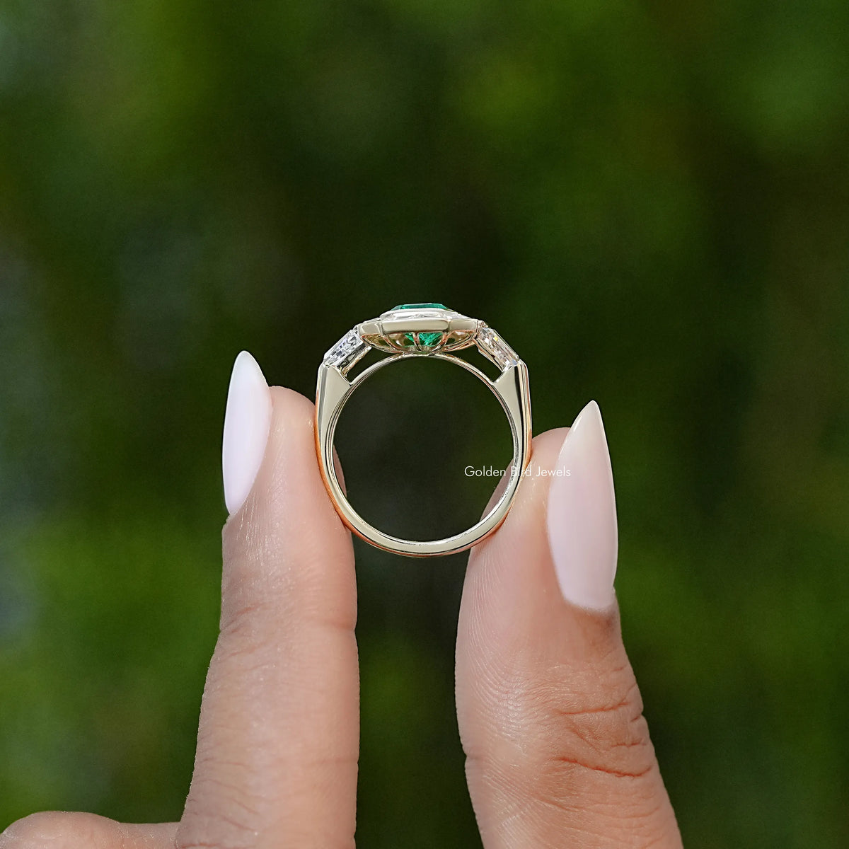 Silver engagement ring with emerald-green gemstone in octagonal halo, top view