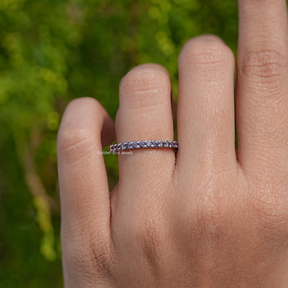 Silver amethyst eternity band ring with purple round stones on the finger