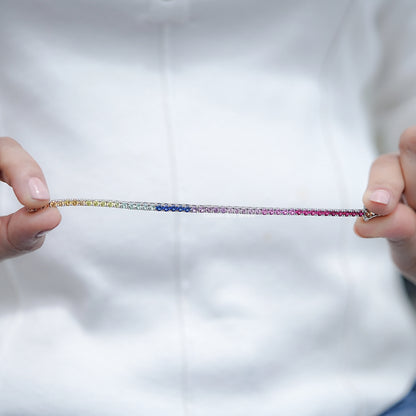 Multi-color gemstone tennis bracelet laid out, alternating purple and blue stones