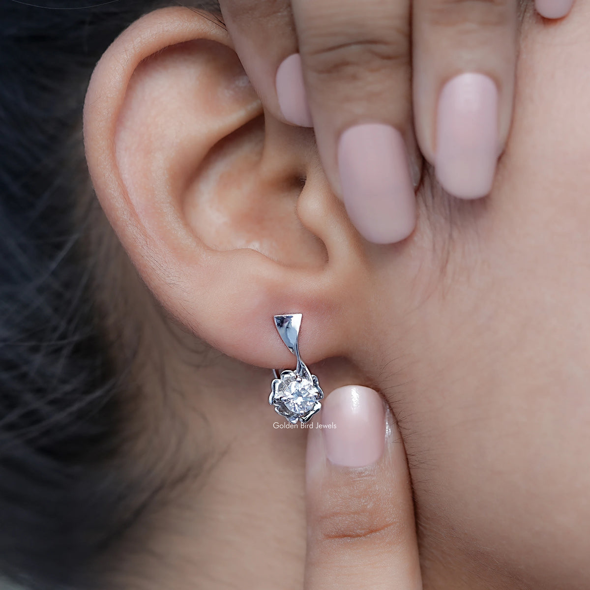 Silver round colorless moissanite cluster earrings with triangular top, ear close-up