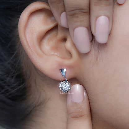 Silver round colorless moissanite cluster earrings with triangular top, ear close-up