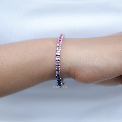 Gradient tennis bracelet on wrist, pink stones with dark blue sections in silver setting.