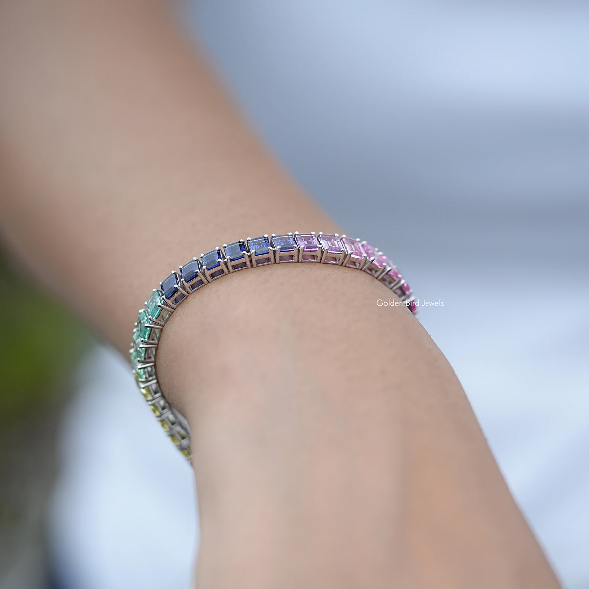 Close-up of multi-color tennis bracelet band with pink, blue and green stones