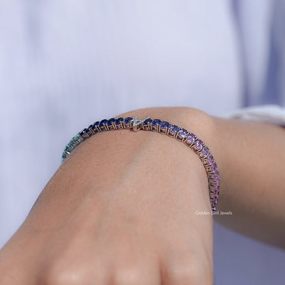Multi-color oval gemstone tennis bracelet with curved row of blue and purple stones