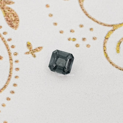 Gray Asscher-cut moissanite gemstone, loose center stone on a light background