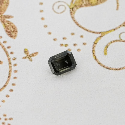 Loose dark gray emerald-cut moissanite gemstone, angular facets