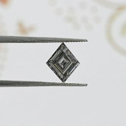 Gray lozenge-cut moissanite with step facets, held between metal tweezers.