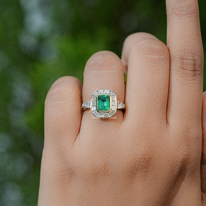 Emerald-green square center halo ring in silver, shown on hand with short band