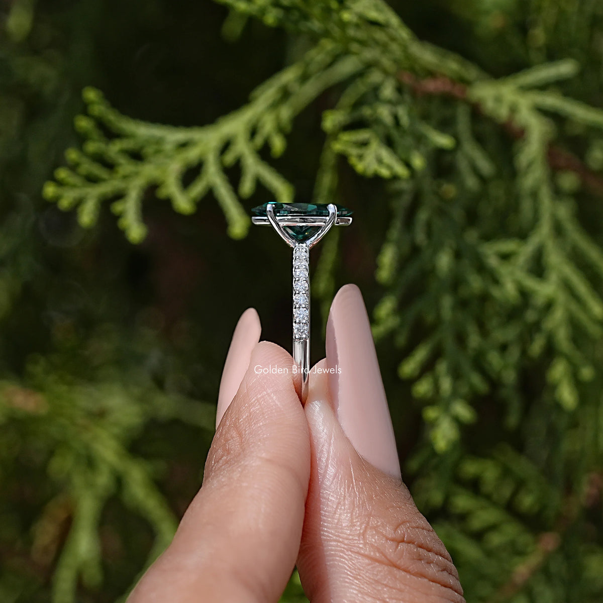 Marquise green moissanite solitaire ring with prong setting and sparkling halo detail.