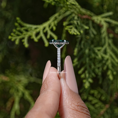 Marquise green moissanite solitaire ring with prong setting and sparkling halo detail.