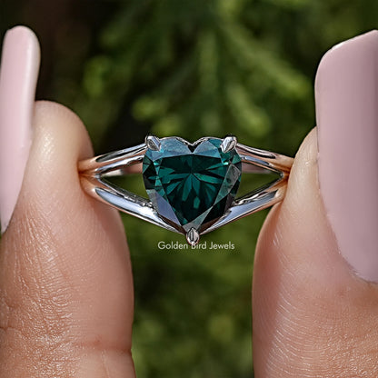 Close-up of sterling silver split-shank ring with heart-cut teal moissanite center