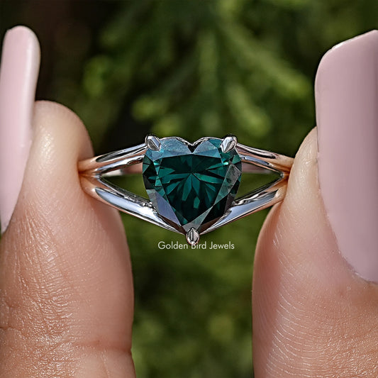 Close-up of sterling silver split-shank ring with heart-cut teal moissanite center