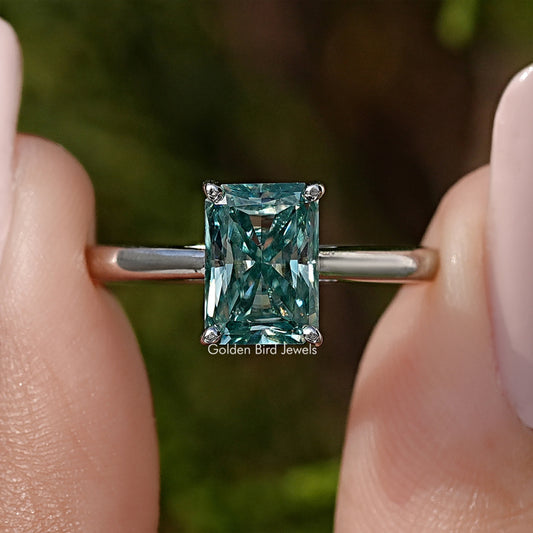 Sterling silver solitaire ring with emerald-cut blue-green moissanite center.