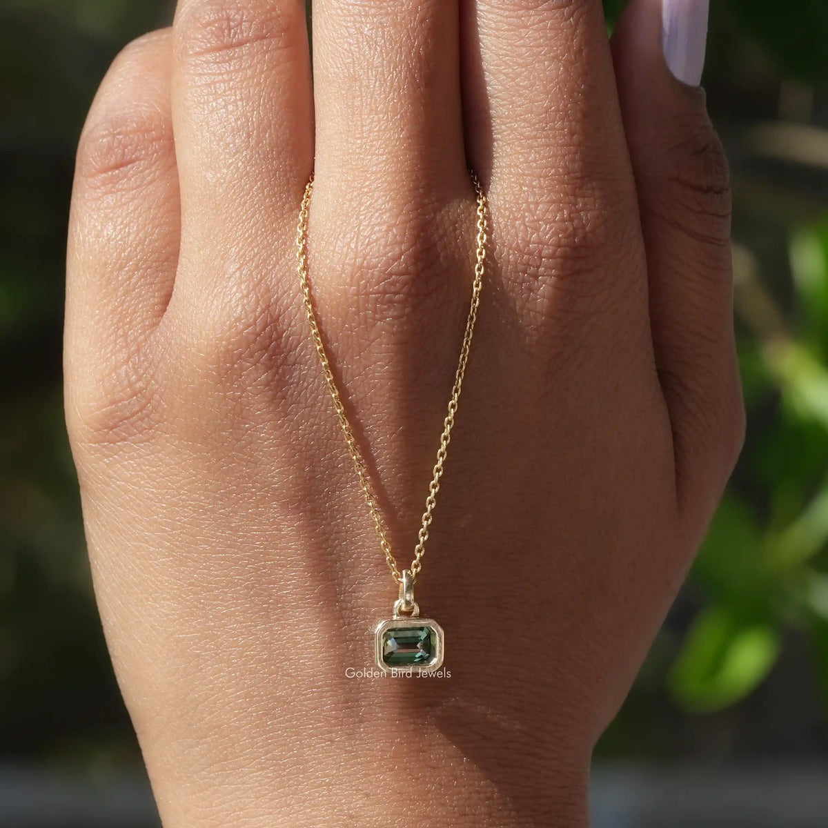 In hand showing view of moissanite pendant	 		