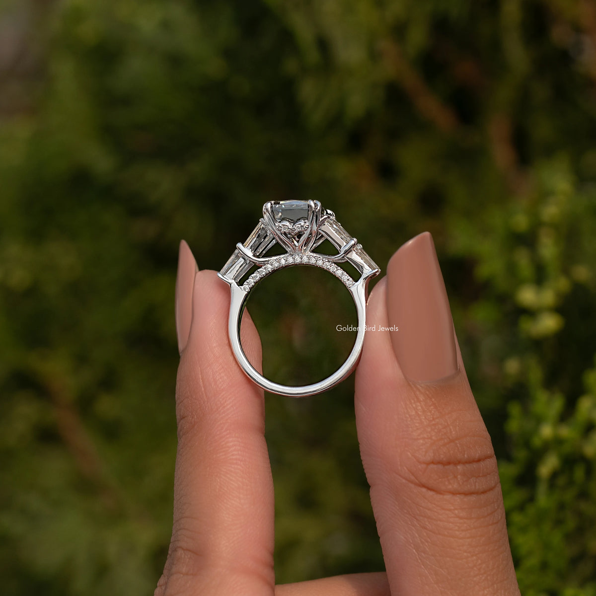 Sterling silver ring viewed from above with rectangular center stone and prong-set accents