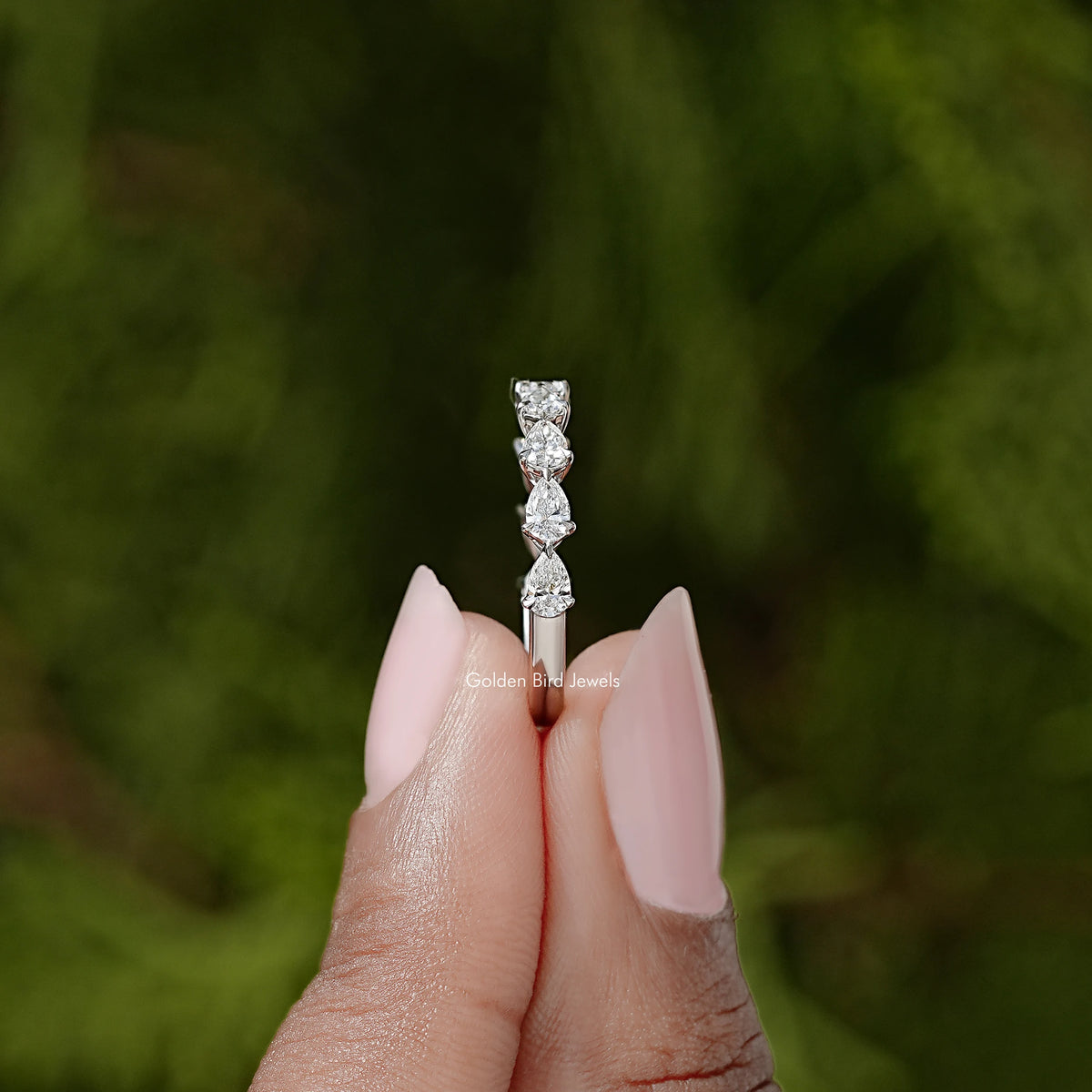 Pear-cut diamond eternity band detail with stacked prong-set stones on a slim silver strip