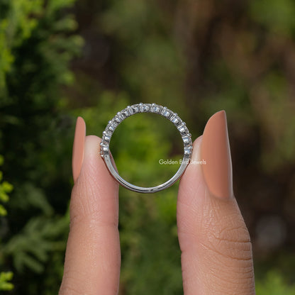 Silver-tone half eternity moissanite band with round stones, arched view on hand