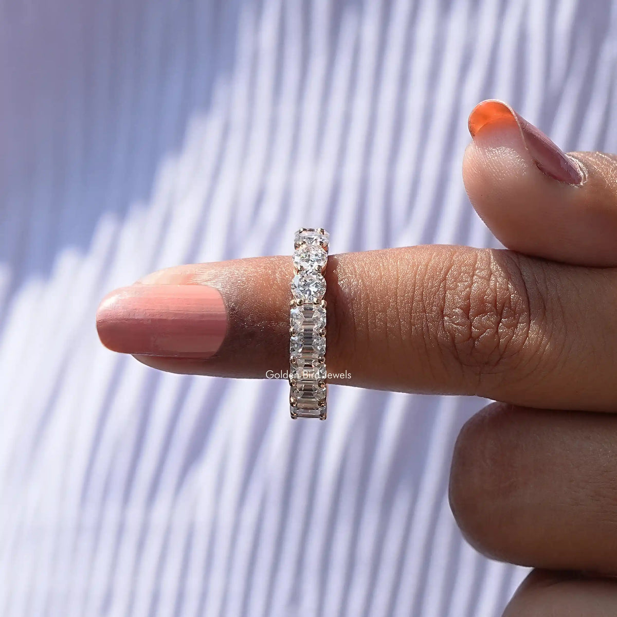 Slim moissanite eternity band with round stones, side view on finger