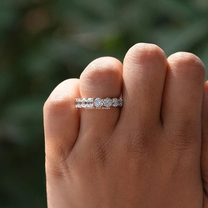 Round-cut moissanite band ring with prong settings, worn on hand