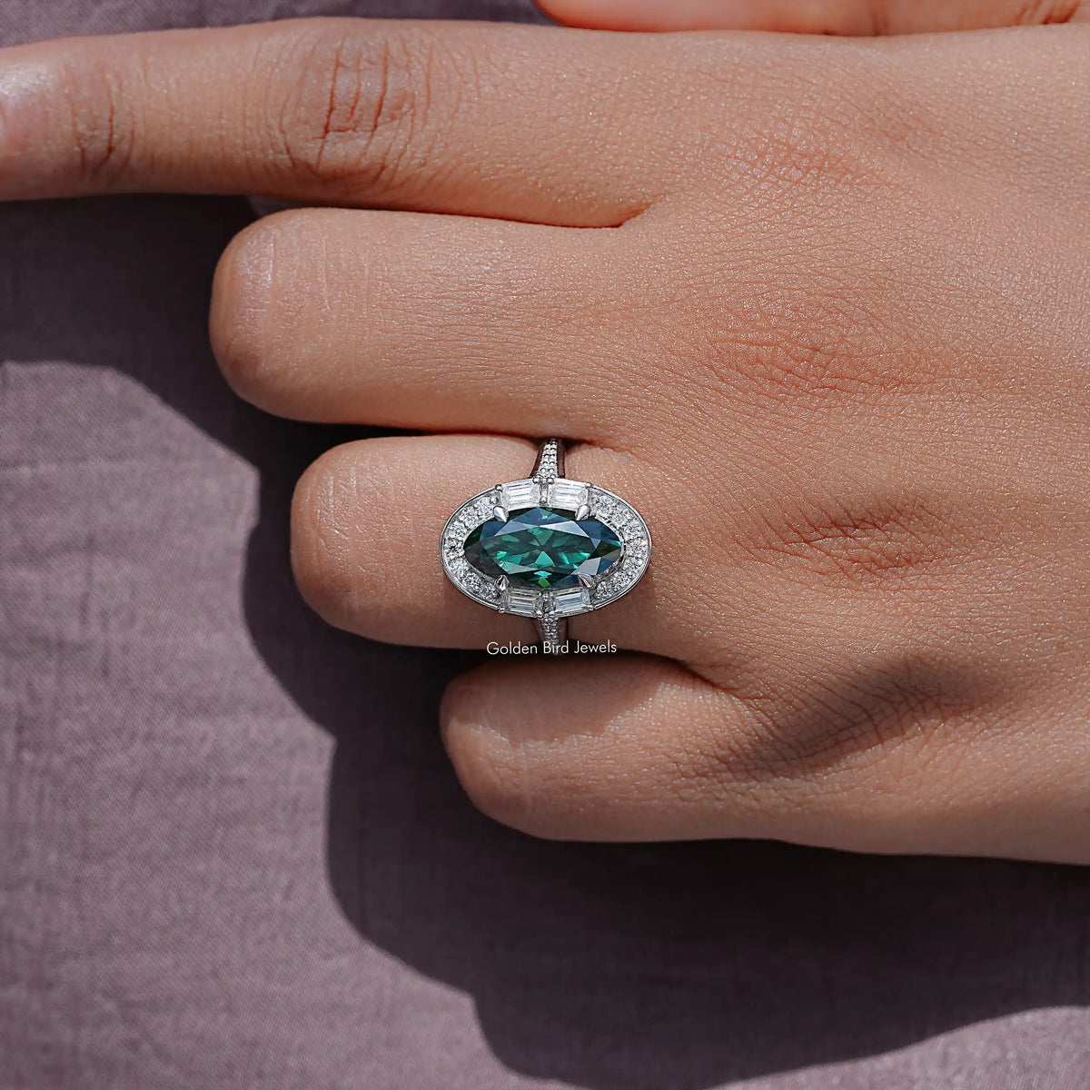 Moissanite halo ring with dark green oval center stone on a silver band