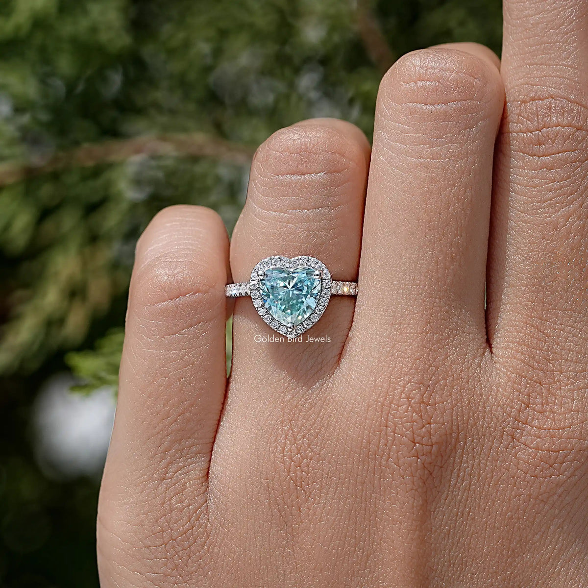 Heart-cut blue gemstone wedding ring in sterling silver, on finger