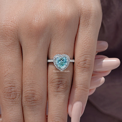 Heart-cut blue gemstone halo ring, sterling silver band on hand