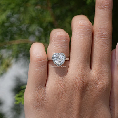 Heart-cut moissanite halo ring with heart-shaped center stone, on finger