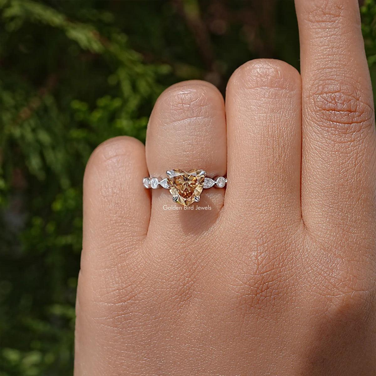 Heart-shaped moissanite wedding ring with round side stones, sterling silver band on hand