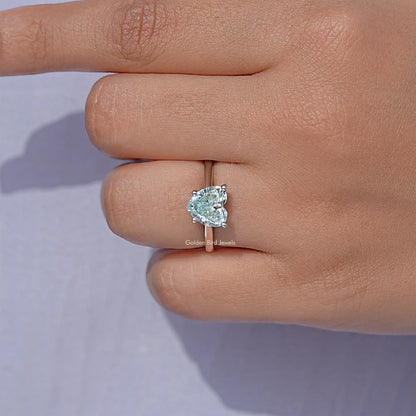 Sterling silver solitaire ring with faceted gemstone, held between fingers