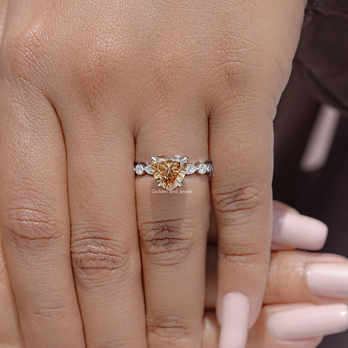 Heart-shaped moissanite ring with white round side stones on a sterling silver band