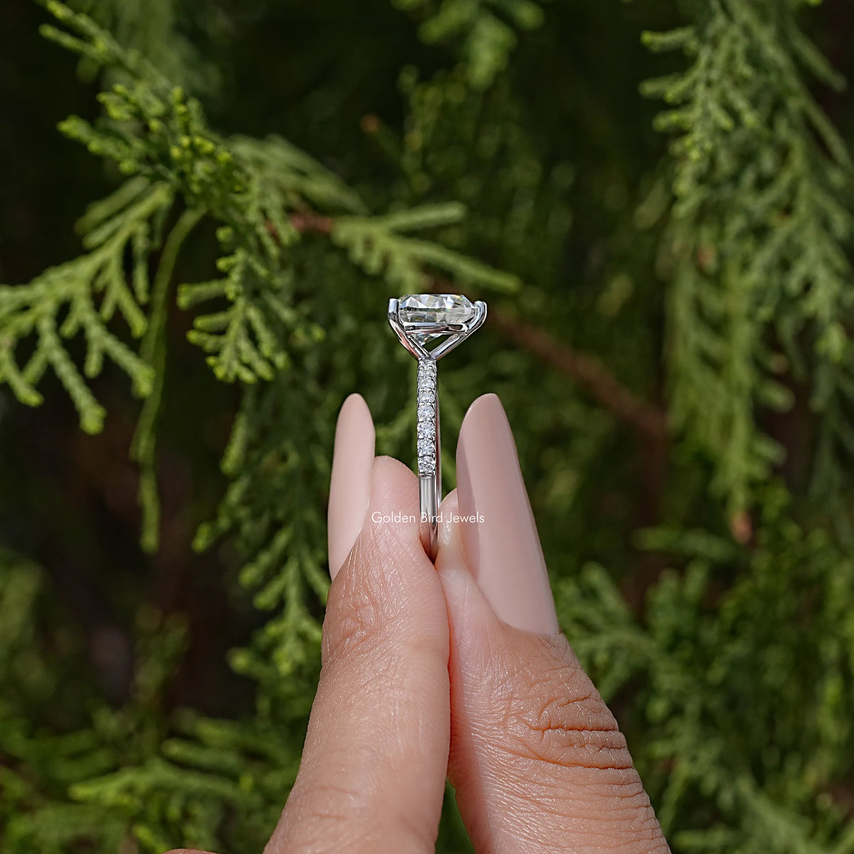 Heart-shaped moissanite solitaire ring on hand with raised center setting