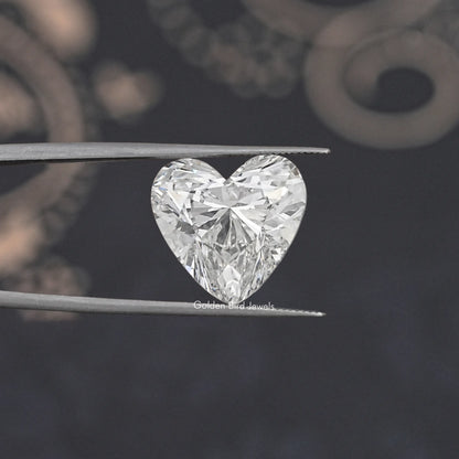 Heart cut lab-grown diamond held in silver tweezers, close-up