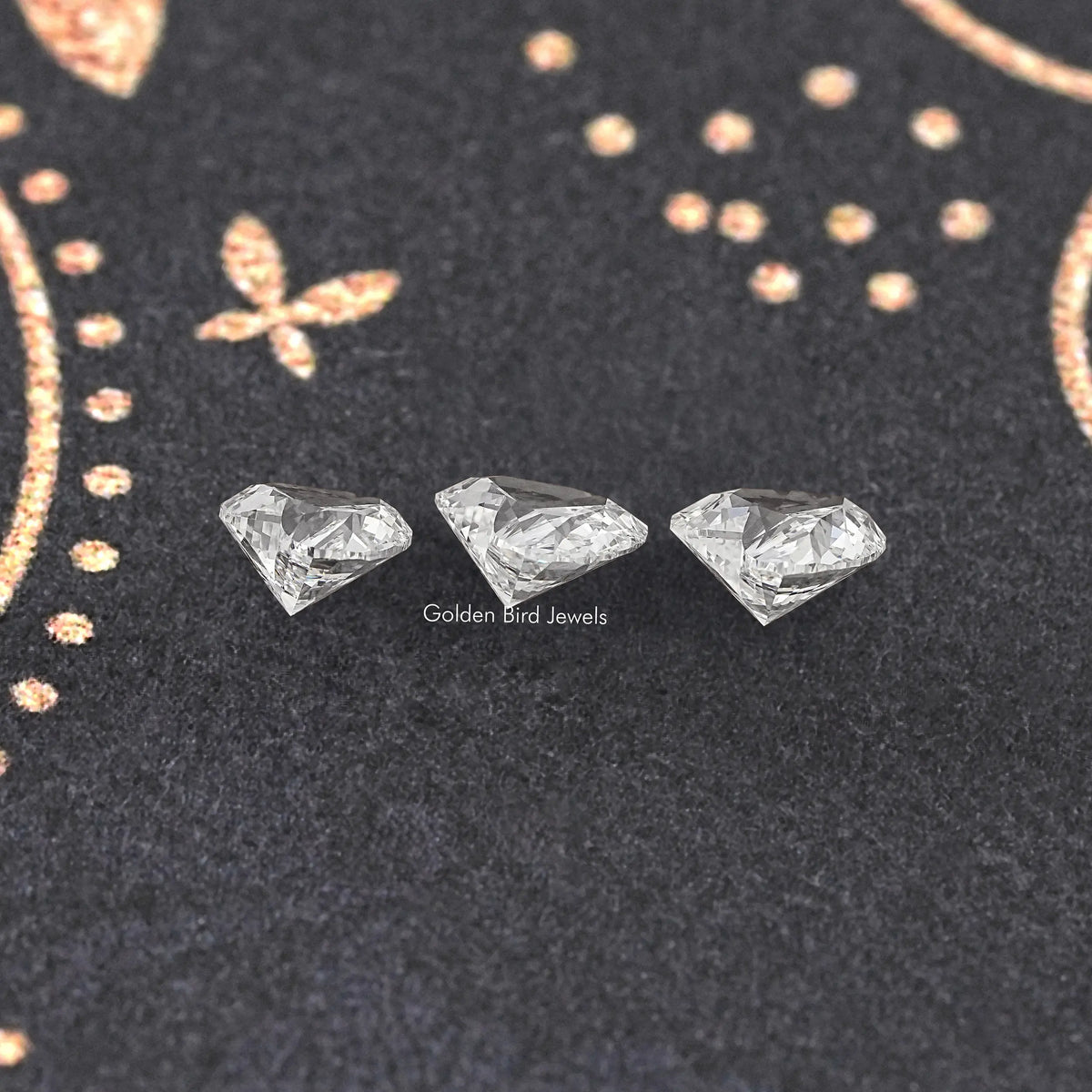 Loose heart cut lab-grown diamonds, three stones on dark fabric
