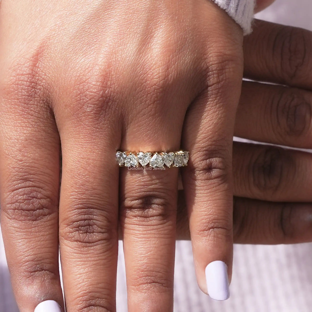 Close view of moissanite half eternity ring with stacked stones on the finger