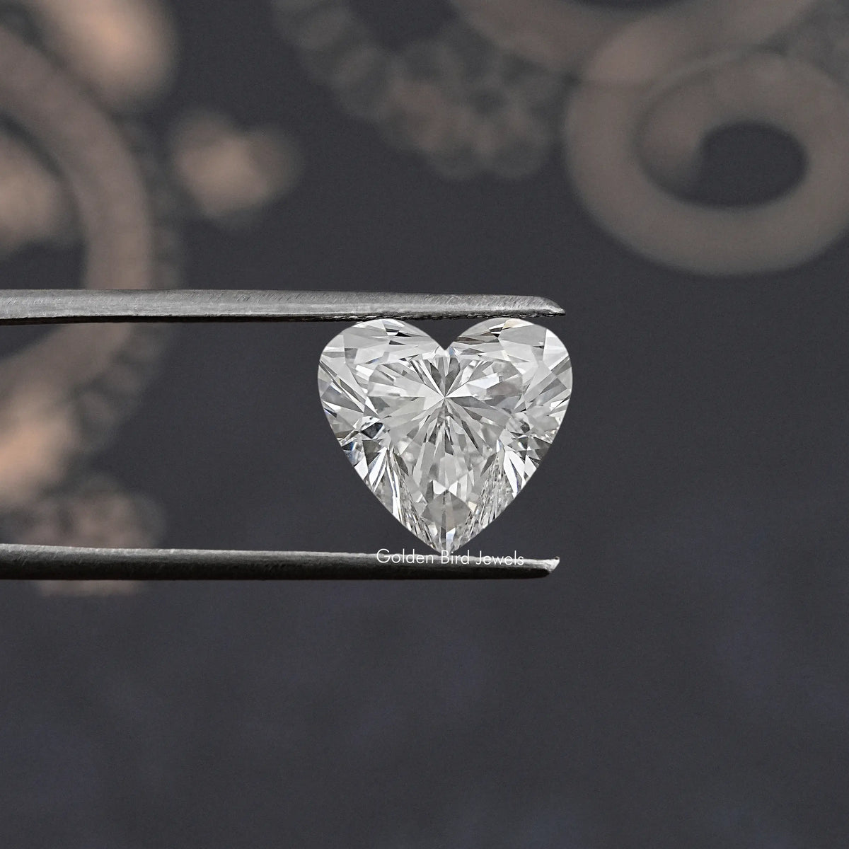 Heart lab diamond held in metal tweezers, large brilliant facets close-up