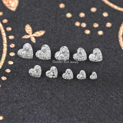 Assorted loose heart-shaped lab diamonds, multiple faceted stones arranged