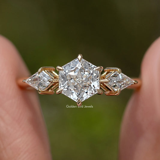 Three-stone diamond ring close-up of center stone with marquise side stones, yellow gold