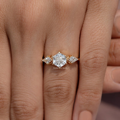 Three-stone diamond ring on fingers with faceted center stone and two side stones, gold