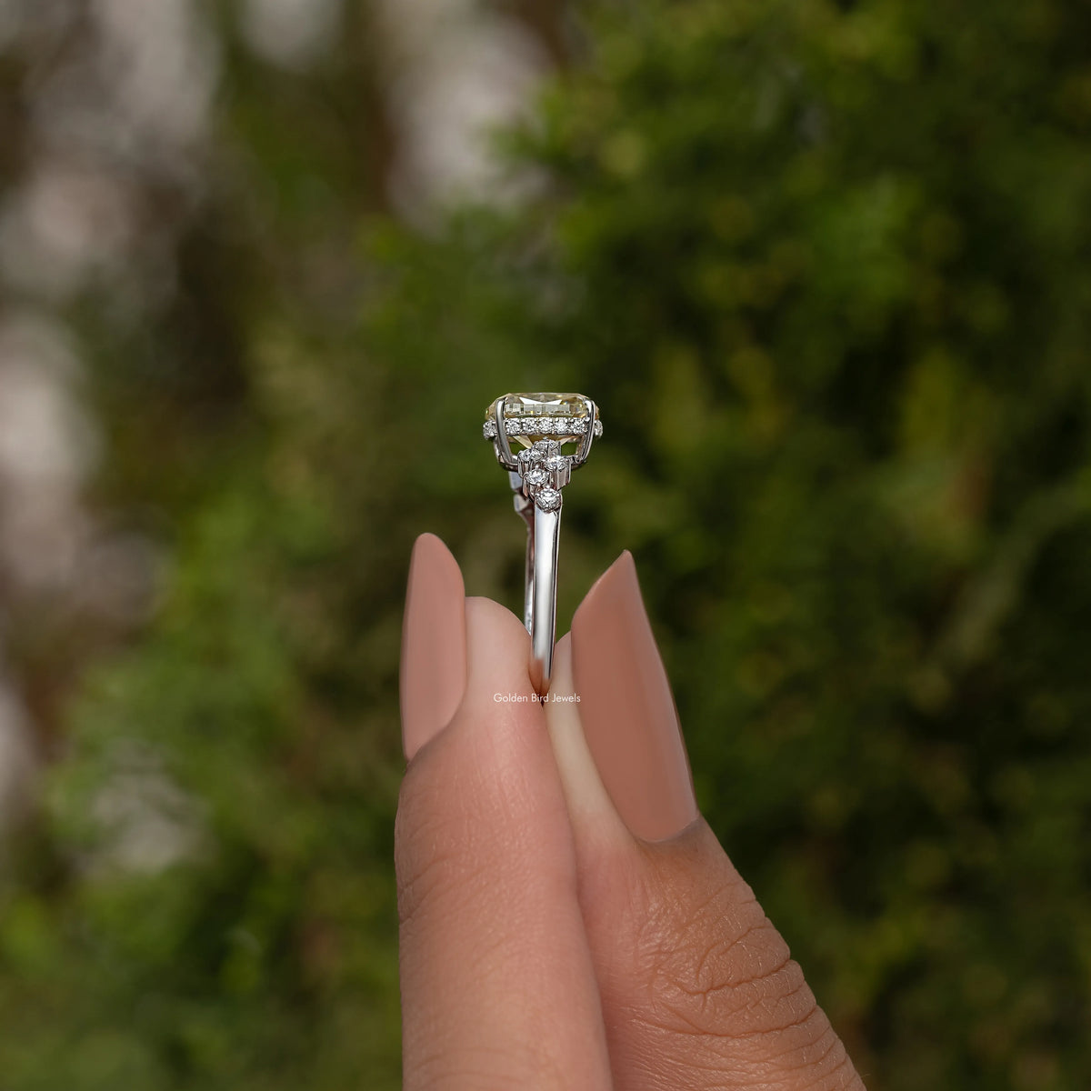 Sterling silver moissanite engagement ring with raised cushion-cut center stone in prongs