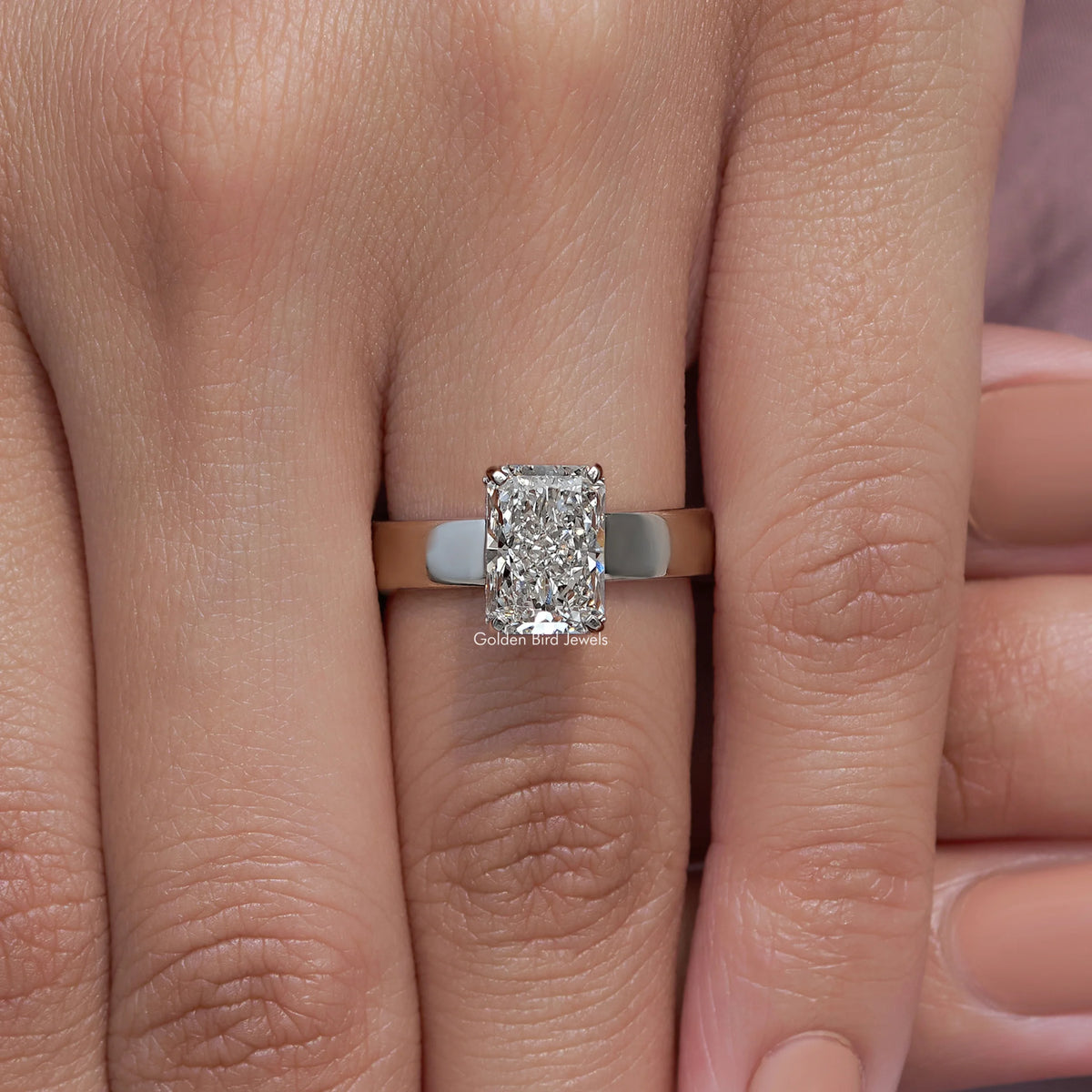 Square-cut diamond engagement ring with silver band on two fingers