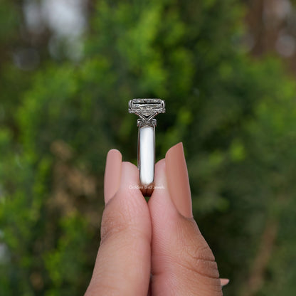 Side view of square-cut diamond ring showing silver prongs and band
