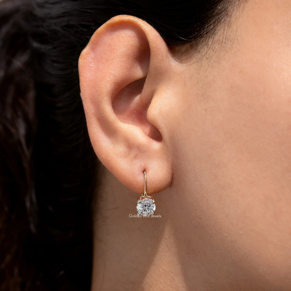 Gold-tone round lab-grown diamond drop earring on ear with hoop top