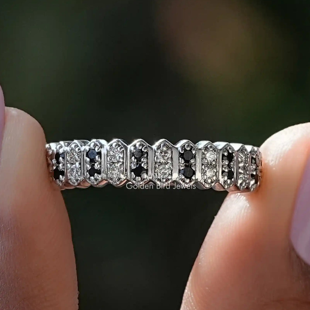 Round cut gemstone half eternity band with alternating clear and dark stones
