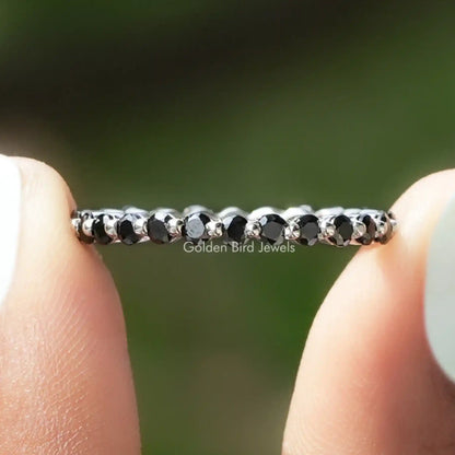 Full eternity band with dark round bezel-set gemstones along the silver-tone ring